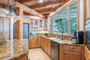 una cocina con armarios de madera y encimeras de granito en Havencrest Luxury Home with Long Range Mountain & Lake Lure Views!, en Old Fort