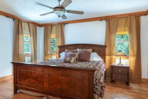 1 dormitorio con cama de madera y ventilador de techo en Havencrest Luxury Home with Long Range Mountain & Lake Lure Views!, en Old Fort