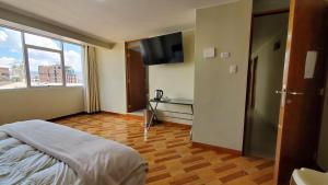 a bedroom with a bed and a flat screen tv at Hotel Wanka Palace in Huancayo