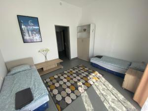 a small room with two beds and a rug at Tocc Apartman in Gyál