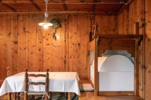 een kamer met een tafel en een stapelbed bij Appartamento La Tana sulle Dolomiti in San Vito di Cadore