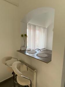 een eetkamer met 2 stoelen en een spiegel bij Tocc Apartman in Gyál