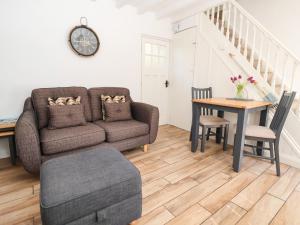 a living room with a couch and a table at Sandy Shell Cottage in Conwy