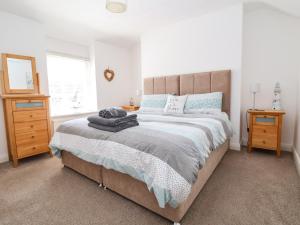 a bedroom with a large bed and two night stands at Sandy Shell Cottage in Conwy