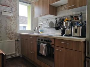 La cuisine est équipée de placards en bois et d'un four avec plaques de cuisson. dans l'établissement Quiet apartment with green view in urban location, à Brunswick