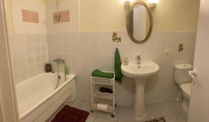 a bathroom with a sink and a tub and a toilet at Valentina's Rooms in Vilnius