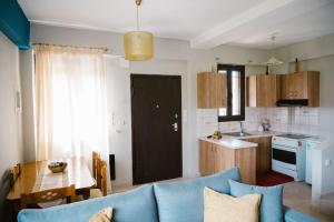 a living room with a blue couch and a kitchen at Ονειρόπετρα in Synikia Mesi Trikalon