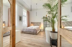 ein Schlafzimmer mit einem Bett und einer Topfpflanze in der Unterkunft Kamienica Centrum Apartament nr 14 in Stettin