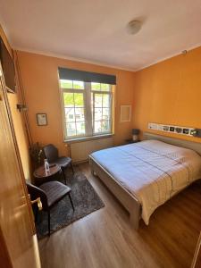 a bedroom with a large bed and a window at Hotel Le Luxembourg in La Roche-en-Ardenne