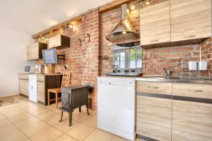 a kitchen with a brick wall and a stove at ORZECHÓWKA in Lądek-Zdrój +42 photos