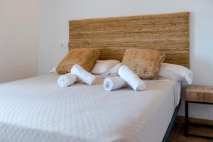 Una cama con tres almohadas encima. en Apartments Es Clot des Forn, en Es Pujols