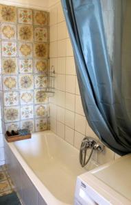 uma casa de banho com banheira e cortina de chuveiro em Thea Apartment em Tessalônica