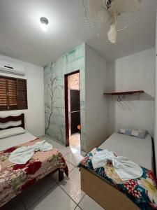 a bedroom with two beds and a fan at Pousada Vancele in Bonito
