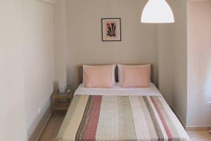 - une chambre avec un lit et 2 oreillers roses dans l'établissement Thea Apartment, à Thessalonique