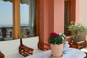 uma mesa com um sofá branco e flores em Thea Apartment em Tessalônica