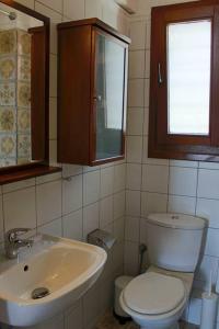 La salle de bains est pourvue de toilettes, d'un lavabo et d'une fenêtre. dans l'établissement Thea Apartment, à Thessalonique