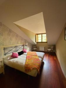 una camera da letto con un grande letto in mansarda di Apartamentos Casa Miño a Pola de Somiedo