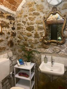 uma casa de banho em pedra com um lavatório e um espelho em Il Casolare em Cantalupo nel Sannio