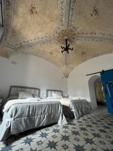 a bedroom with two beds and a coffered ceiling at El palacete azul in Almendral