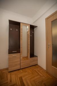 a dressing room with a large mirror and wooden cabinets at Apartman Lena in Trebinje