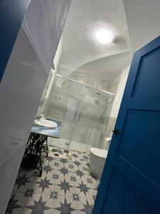 a bathroom with a toilet and a blue door at El palacete azul in Almendral