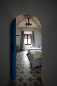 a bedroom with a bed and a chandelier at El palacete azul in Almendral