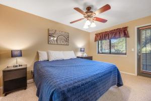 a bedroom with a blue bed with a ceiling fan at Charming Walnut Hills Condo in Flagstaff