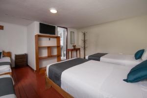 Habitación de hotel con 2 camas y TV en Ayenda Hostal Cusco Sol, en Cusco