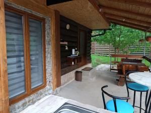d'une terrasse avec des chaises, une table et une fenêtre. dans l'établissement Cottage Auto Camp Vinac, à Jajce