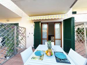 un tavolo bianco con un cesto di frutta sul balcone di Casa Mareluna - ArgonautiVacanze a Marciana Marina