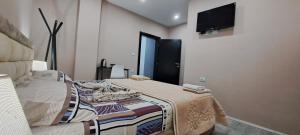 a bedroom with a bed and a flat screen tv at CityCenterHotel Shkoder in Shkodër