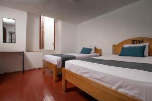 Habitación con 2 camas y espejo. en Ayenda Hostal Cusco Sol, en Cusco