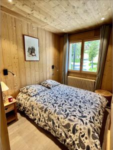 Schlafzimmer mit einem Bett und einem Fenster in der Unterkunft Résidences DELAVAY LA FERME in Les Gets