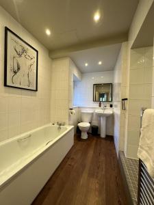 a bathroom with a tub and a toilet and a sink at The Beeches - Chatsworth Apartment No 1 - Sleeps 2 in Baslow