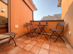 a balcony with two chairs and a table on it at Rooftop 85qm - Burgblick - nahe Heidelberg - Loggia - Büro - Klima in Schriesheim