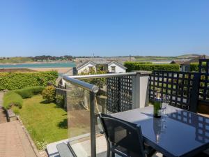 a blue table and chairs on a balcony with a view at Tides in Padstow