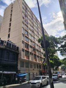 Un grand bâtiment avec des voitures garées devant lui dans l'établissement AgattaGuia&Hospeda Lapa Rio 1103, à Rio de Janeiro