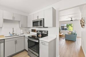 a kitchen with white cabinets and a stove top oven at Lovely 1-bedroom condo in Biltmore - Parking in Phoenix