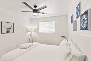 a white bedroom with a bed with a ceiling fan at Lovely 1-bedroom condo in Biltmore - Parking in Phoenix +10 photos