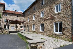 a brick building with a bench in front of it at Hôtel Des Voyageurs in Bellevue-la-Montagne