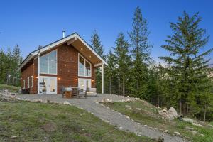 una casa en la cima de una colina con árboles en Little Tooth Retreat - Big Cabin, en Sandpoint
