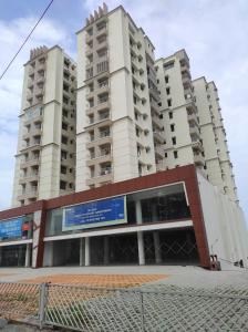 two tall apartment buildings in front of a building at Olive Celestina in Kottayam