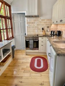 WE ARE UNIQUE ! 4 min walk to Beach, Pubs, Restaurants, Shops, Htd Pool, Hottub, Games rm, 1 acre Garden, BBQ, Stunning walks, Historic Bassets acre, 6 x 1-3 bedroom Superior aparts, Free Parking and WIFI في برتريث: مطبخ مع سجادة حمراء على الأرض