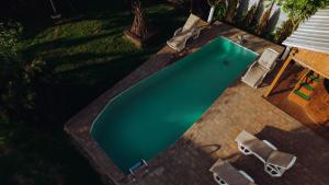 an overhead view of a swimming pool with two chairs at Căsuța de sub deal - SPA & More in Măgura