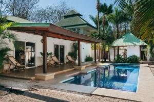 une maison avec une piscine en face d'une maison dans l'établissement Dream Surf House Avellana, à Playa Avellana