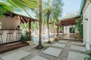 une maison avec une piscine et des palmiers dans l'établissement Dream Surf House Avellana, à Playa Avellana
