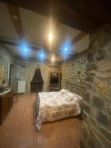 um quarto com uma cama e uma parede de pedra em Il Casolare em Cantalupo nel Sannio