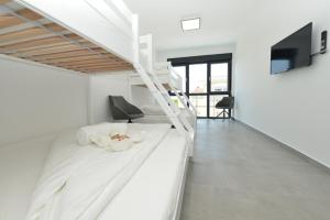 Villa Ana في فرسي: غرفة نوم بيضاء مع سرير وتلفزيون