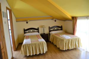 Duas camas num quarto com paredes amarelas em Hostal Infanta Doña Leonor em Palencia