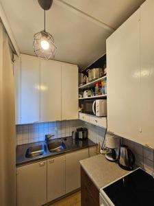 a kitchen with white cabinets and a sink at Comfortable 1 bedroom apartment in Helsinki in Helsinki